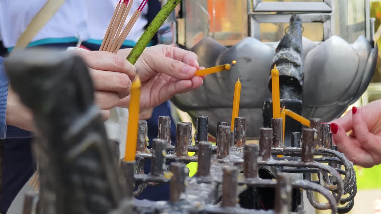 불교 사원 에서 기도 하고 불 을 켜고 있는 사람 들