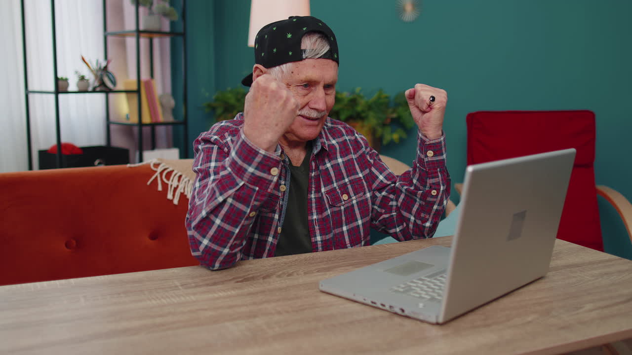 muy feliz anciano abuelo hombre con portátil celebrar el éxito ganar dinero en la lotería en línea buenas noticias