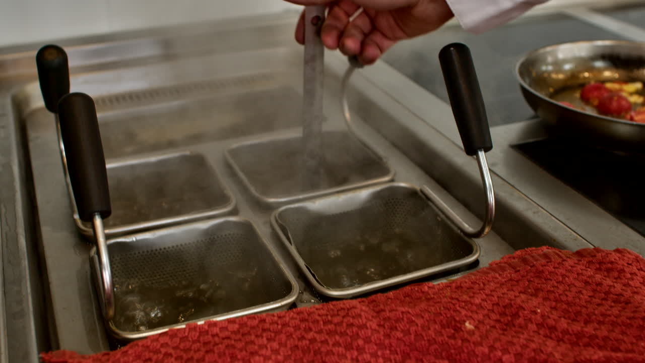 Shot of a professional kitchen prep area featuring multiple stainless steel gastronorm containers with sauces and ingredients. Organized culinary workspace in a generic setting