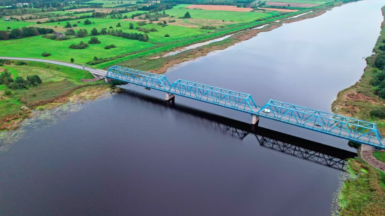 Bridge connects land across the river in rural Latvia landscape