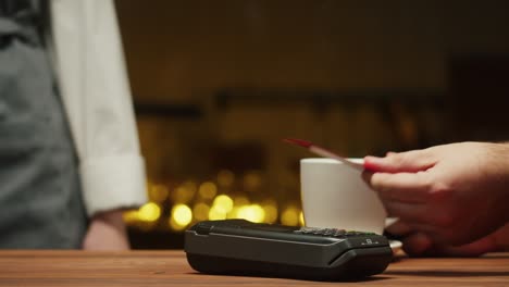 paying with credit card in caffe close-up. cashless shopping in restaurant. touch-free and contactless payment concept. nfc technology and bank terminal. buying coffee.