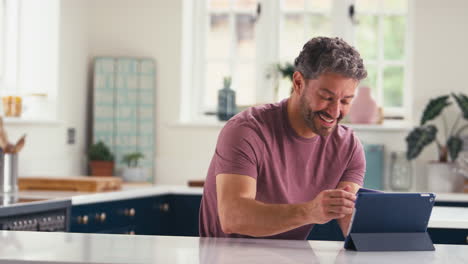 Mature-Man-With-Credit-Card-Using-Digital-Tablet-At-Home-To-Book-Holiday-Or-Shop