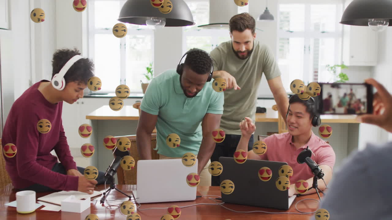 Five men recording podcast in kitchen using laptops and mics, showcasing floating emoji graphics