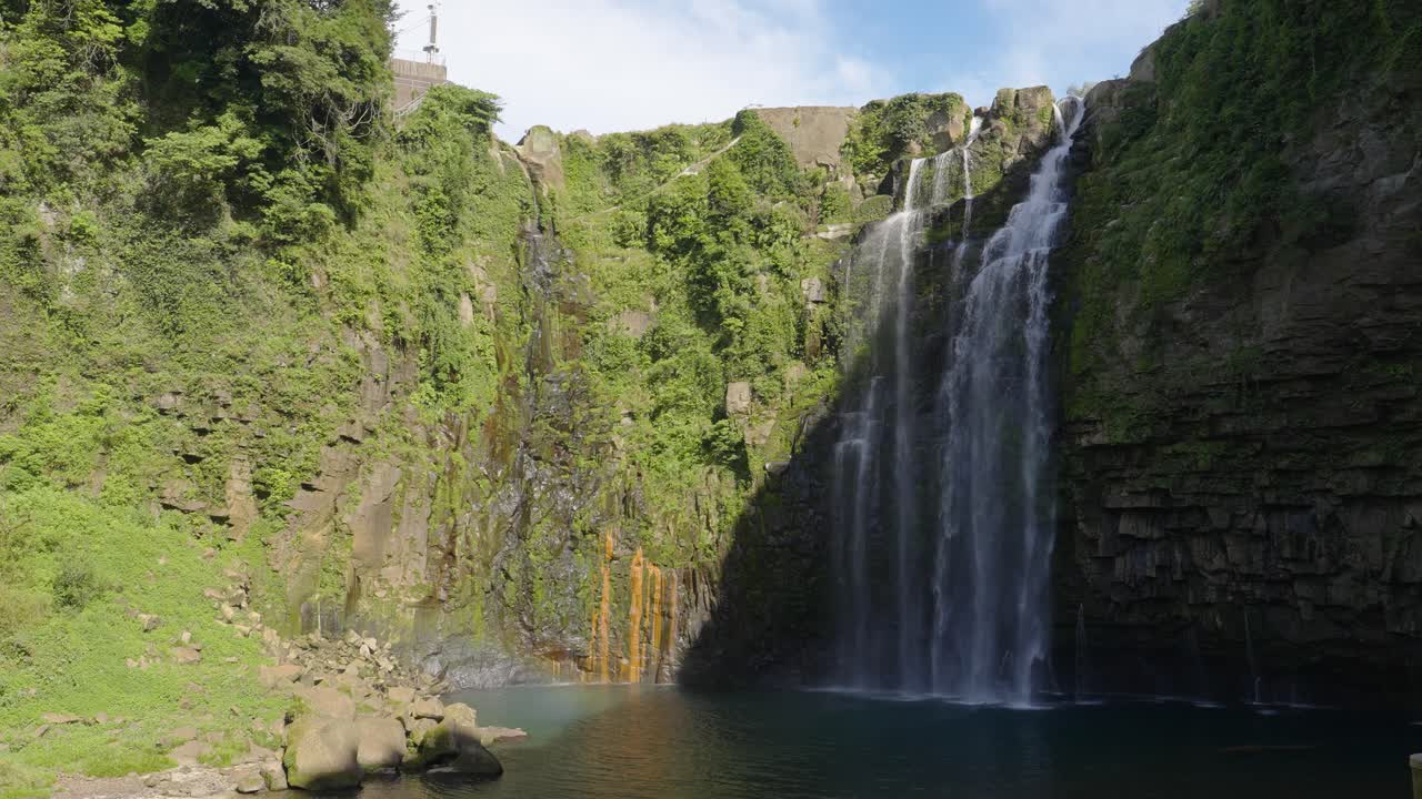 una foto amplia de las cataratas de ogawa que caen por la roca en la piscina, kagoshima, japón