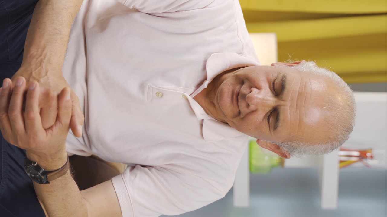 vídeo vertical de un anciano emocional mirando por la ventana.