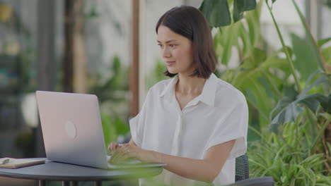 businesswoman working on laptop in outdoor cafe