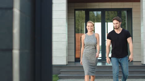 Successful-man-and-woman-walking-straight-near-luxury-house.