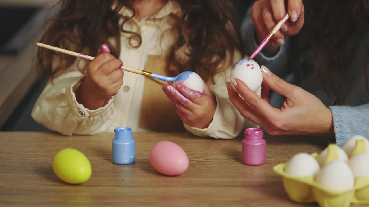 мать и дочь рисуют пасхальные яйца