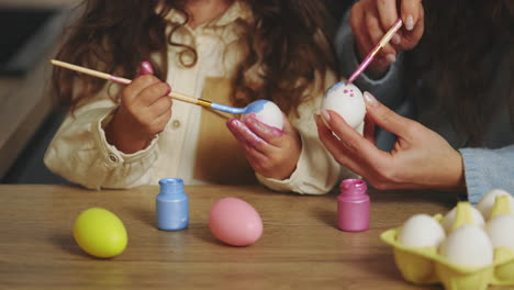 madre e hija pintando huevos de pascua