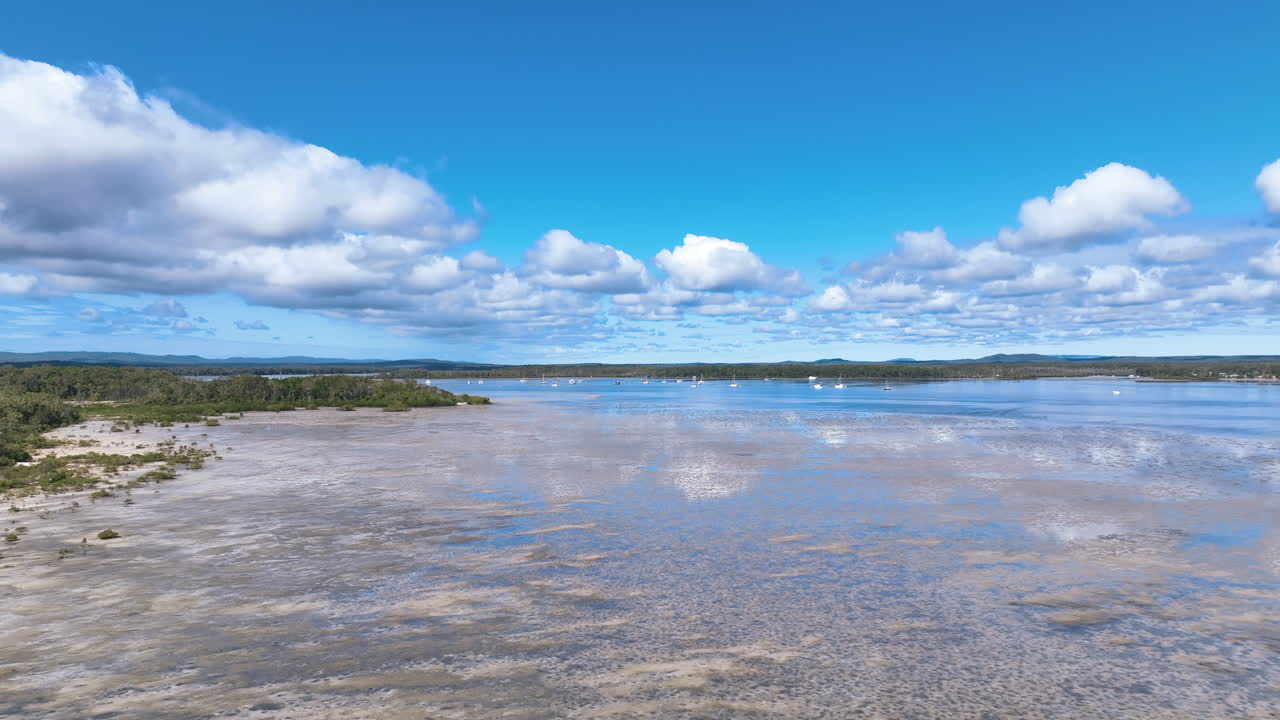 Luftfoto dykker ned til overfladen af glitrende lavvande i Koralhavet, Great Sandy Strait.