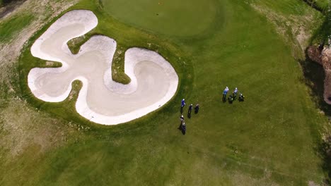 golfers on a golf course with sand trap