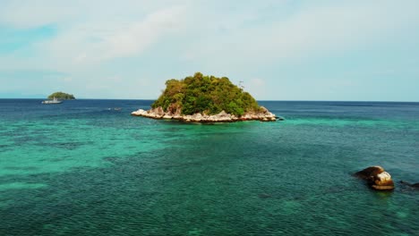 rocky tropical island surrounded by turquoise blue water