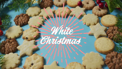 animation of white christmas over cookies on blue surface