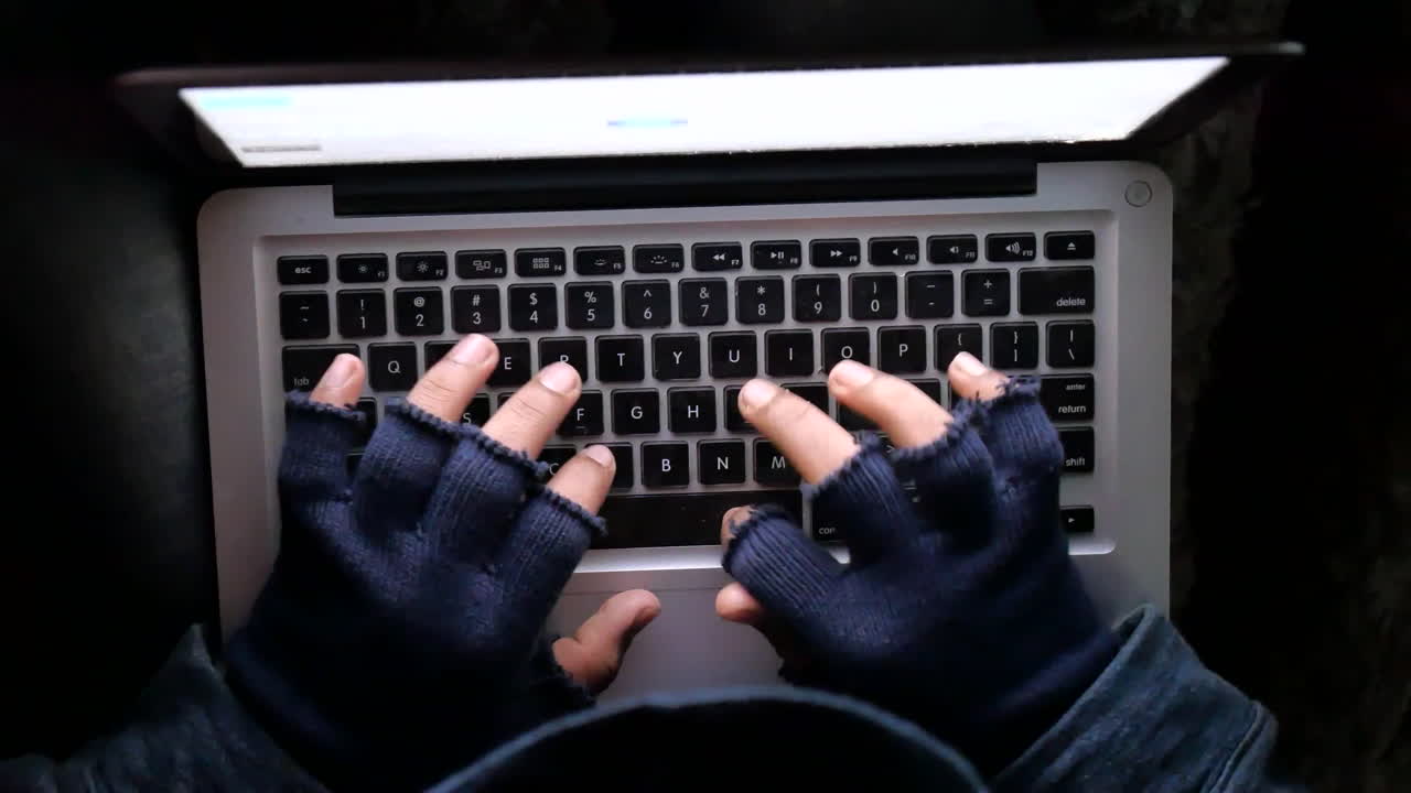 Person using a laptop with gloves