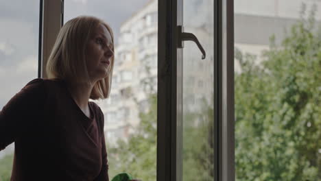 una mujer lava una ventana en el apartamento de un edificio alto 1