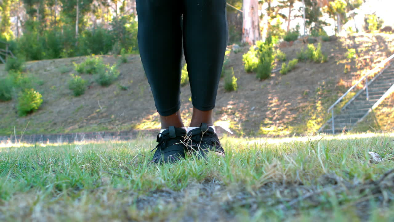 Low-section of woman skipping rope in the park
