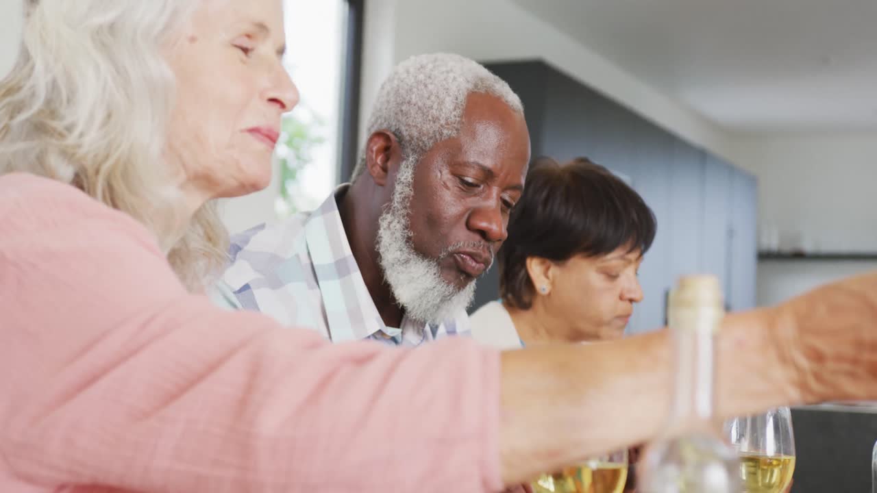Happy senior diverse people having dinner at retirement home
