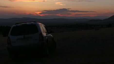 a simple clip of a suv driving off with sunset in the background