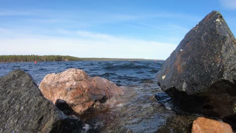 beautiful lake scenery with waves hitting on rocks at shore