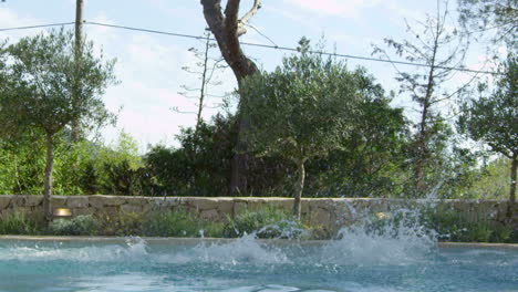 family on vacation jumping into outdoor pool