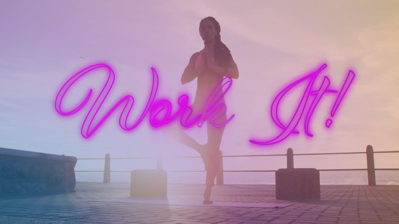 neon púrpura trabajo de texto pancarta contra afroamericano mujer en forma realizando yoga en el paseo marítimo
