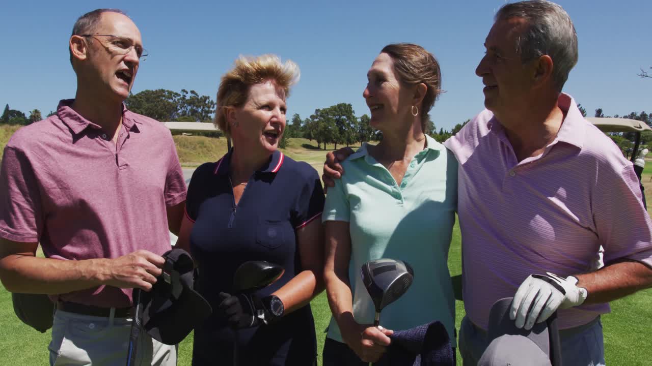 Senior people holding golf clubs talking to each other at golf course