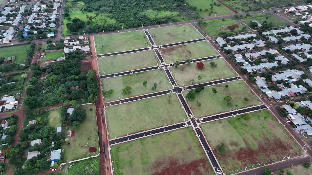 Perspective aerial view of suburban grid layout with grassy and empty housing lots ready for construction, Posadas, Misiones, Argentina