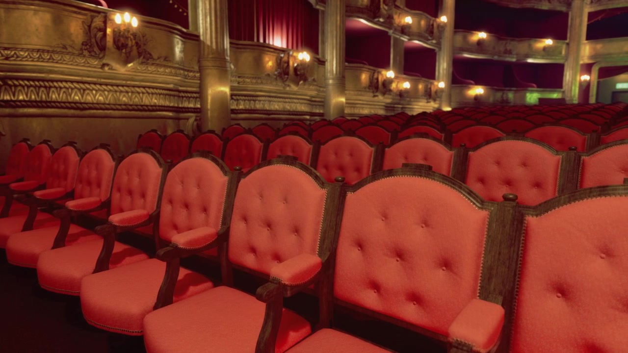 Geräumiges Theater mit vergoldeten Balkonen und sanft beleuchteter Bühnenatmosphäre