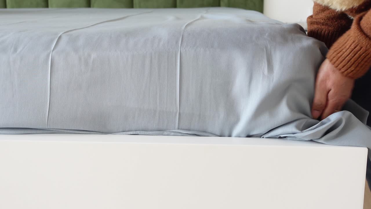 женщина устраивает постель.