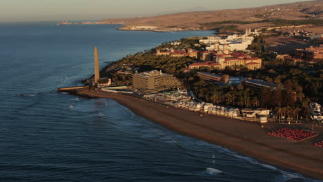 aerial orbit shot lighthouse view during sunset in meloneras district on gran canaria island during magical sunset near maspalomas dunes