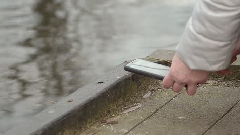 woman using mobile phone by lake