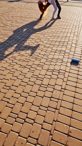 couple is dancing on pavement. legs of two dancers moving together outdoors. professional dancers performing freestyle dance in the street. vertical video