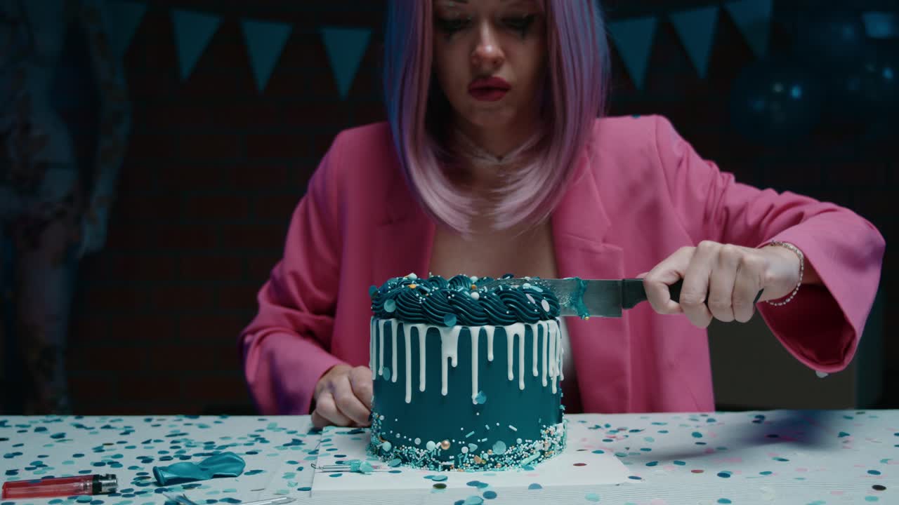 Woman cutting a dark teal themed birthday cake