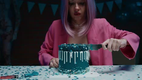 woman cutting a dark teal themed birthday cake