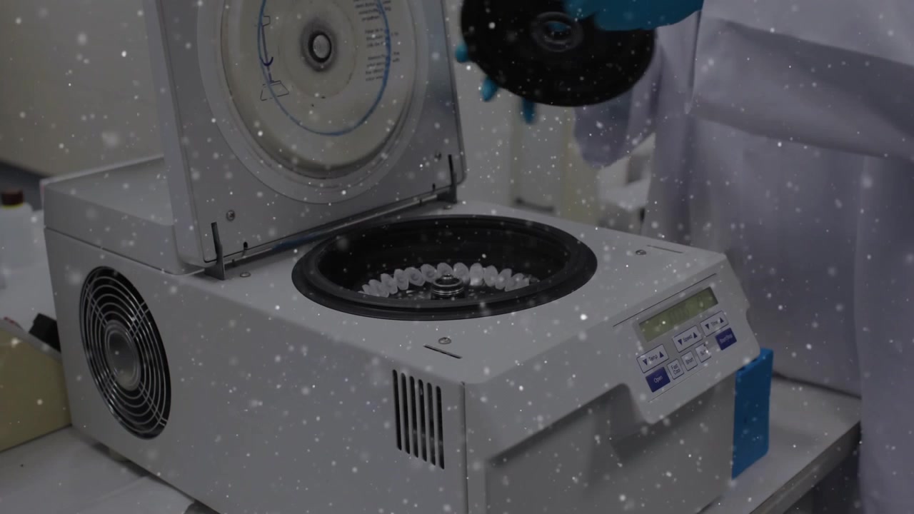 Lab tech gloved hands using panel, lifting lid, seating rotor, preparing centrifuge for analysis