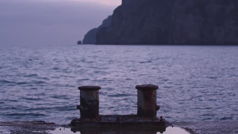 ocean view with mooring posts at dusk