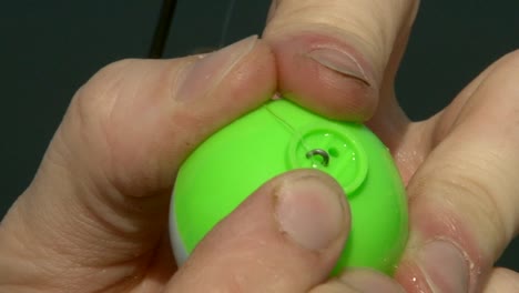 fisherman putting floater on a fishing line. closeup, macro