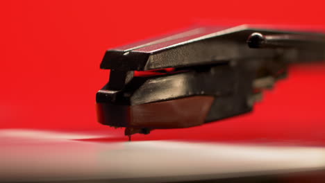 Macro-of-a-vintage-style-red-retro-record-player-and-spinning-vinyl-music-album,-slow-motion