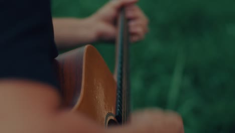 person playing acoustic guitar outdoors