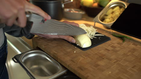 dolly out shot of female hands slicing a white onion