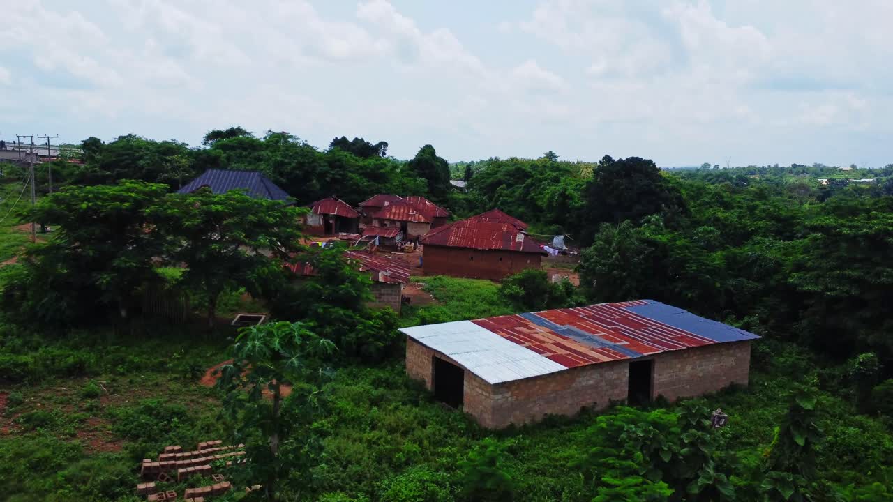 Drone flyver over elledninger mod en lille landsby på landet i Nigeria, Afrika. Luftfoto, der afslører gamle små landsbyhuse i Afrika.