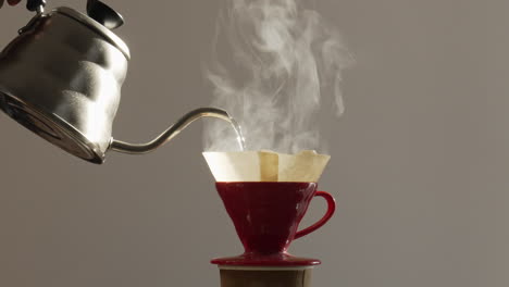 infusione versare sopra il caffè mentre il vapore sale dalla tazza del filtro