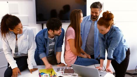 Graphic-designers-interacting-with-each-other-in-conference-room