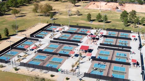un campo de canchas de pickleball en un parque de la ciudad durante un torneo - vista aérea ascendente