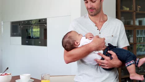 un padre amoroso moviendo a su bebé