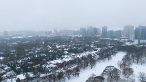 aerial shot of snow covered atlanta suburbs with midtown in the background.