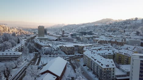 Video-Aéreo-De-La-Estación-Central-Y-El-Casco-Antiguo-Cubierto-De-Nieve,-Sankt-Gallen,-St