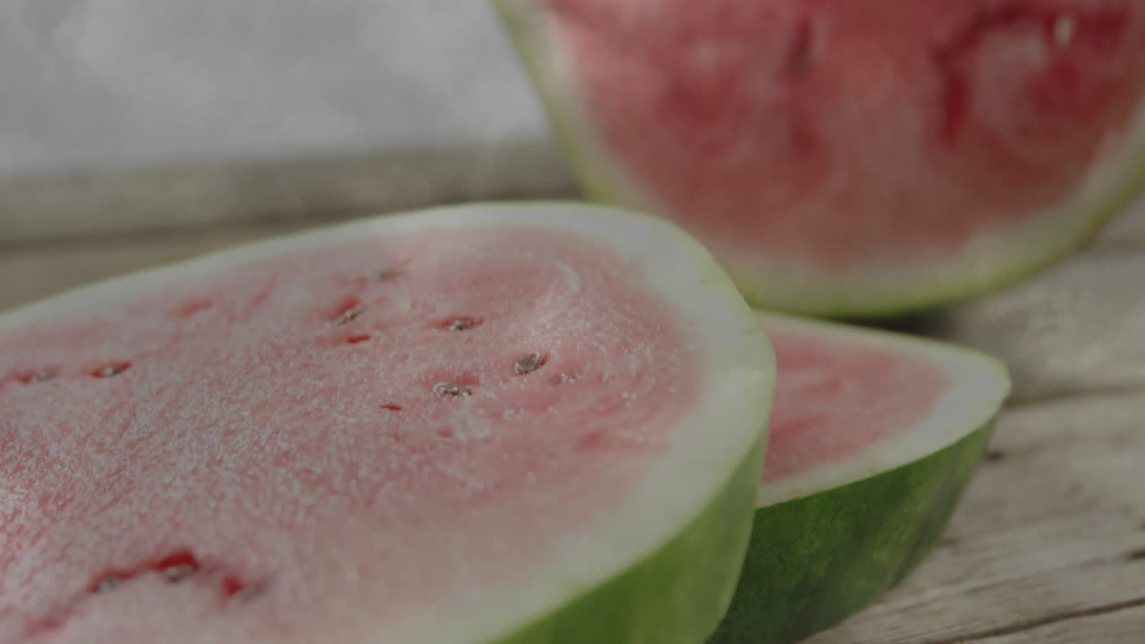 Fresh watermelon slices with seeds on wooden surface, ready for serving