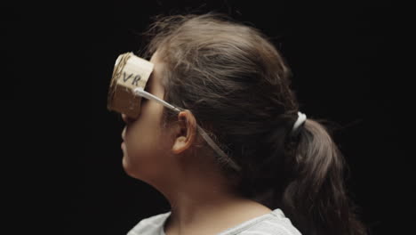 close-up of child wearing cardboard vr headset and pretending to experience virtual world
