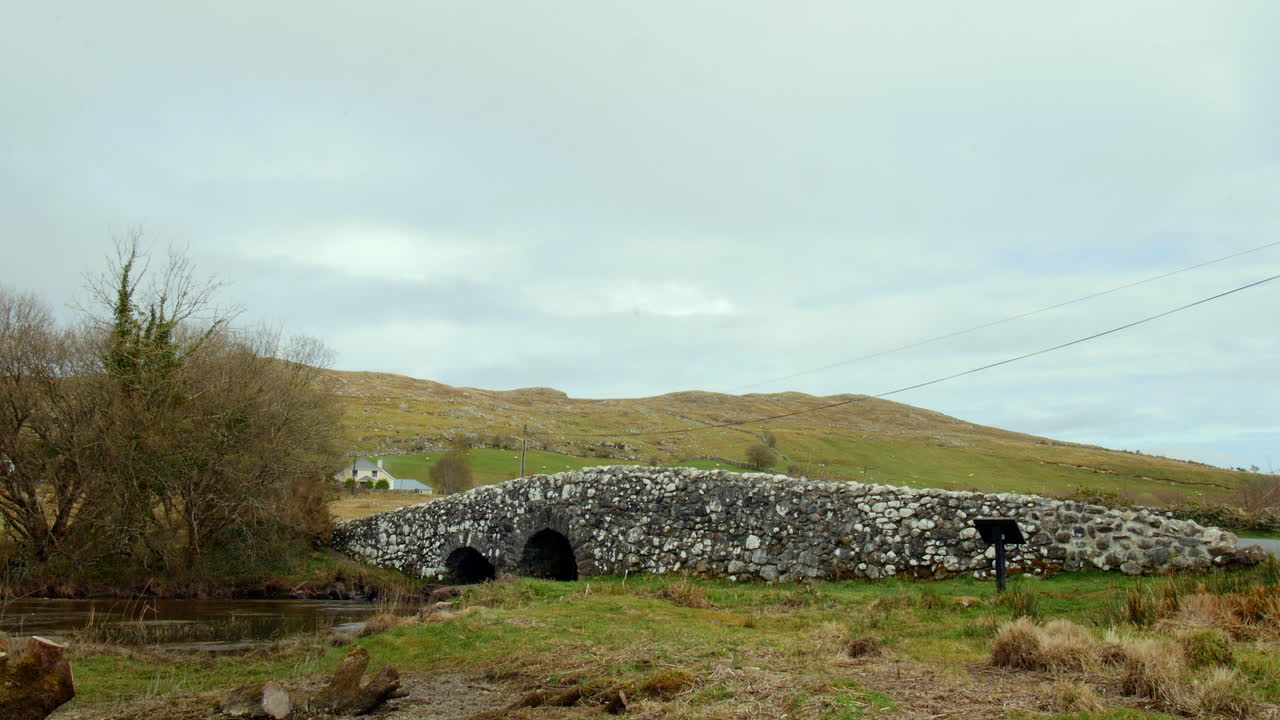 timelapse of Quiet Man Bridge in Connemara, Ireland, with moving clouds and shifting sunlight.
